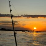 por do sol com vara de pesca
